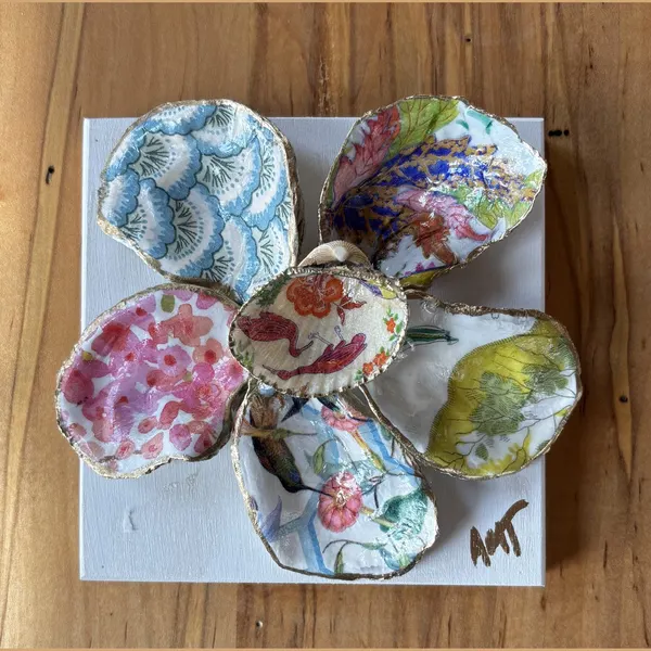A six-petal shell flower wall art with a blue fan pattern, a songbird, and floral petals around a pink bird center.