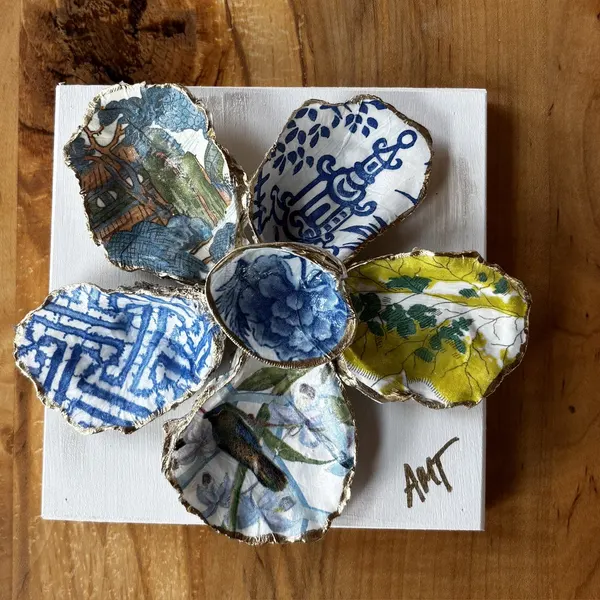 A six-petal shell flower wall art with chinoiserie, hummingbird, and floral patterns around a blue floral center.