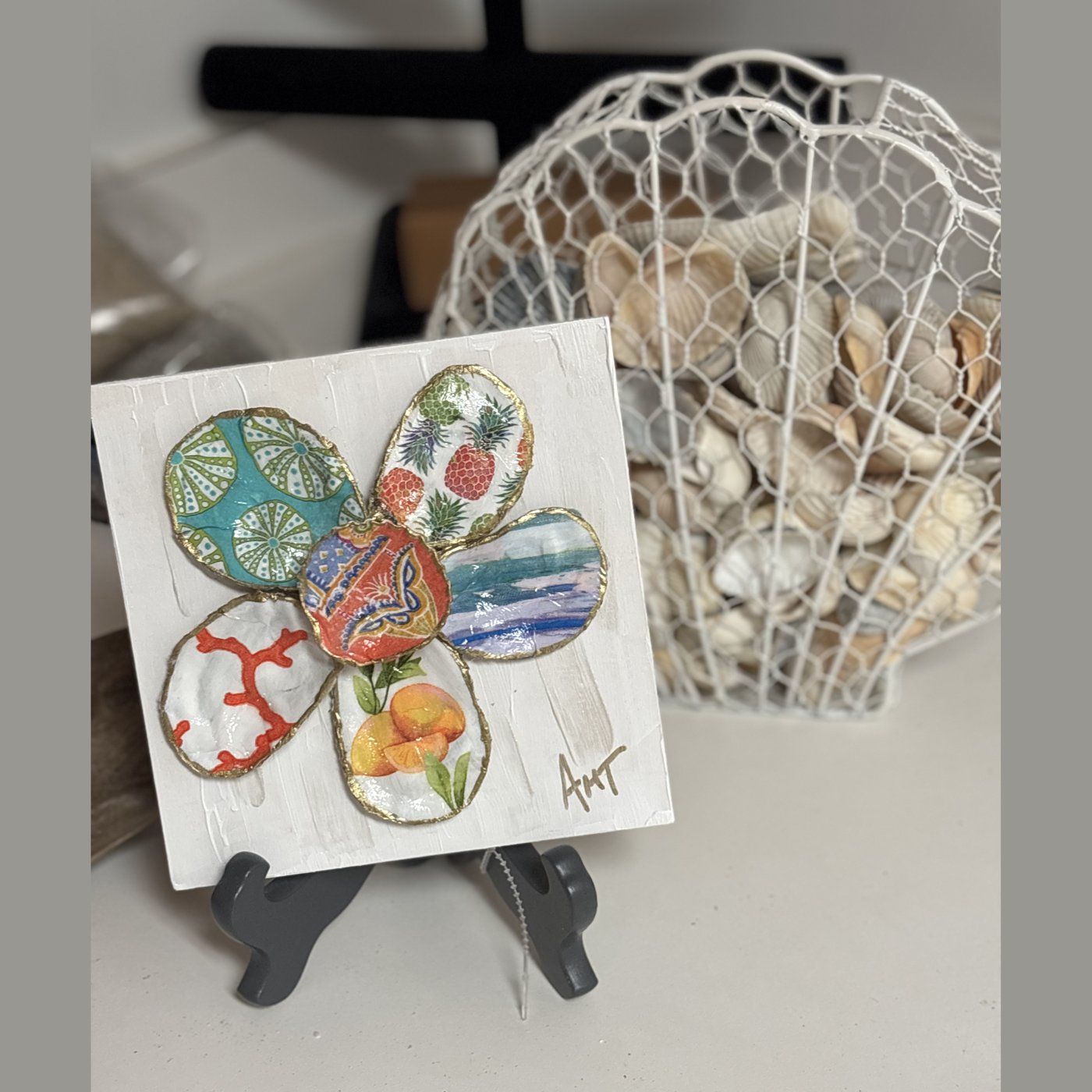 A six-petal shell flower wall art with teal fan, pineapple, and citrus patterns around an orange elephant center.
