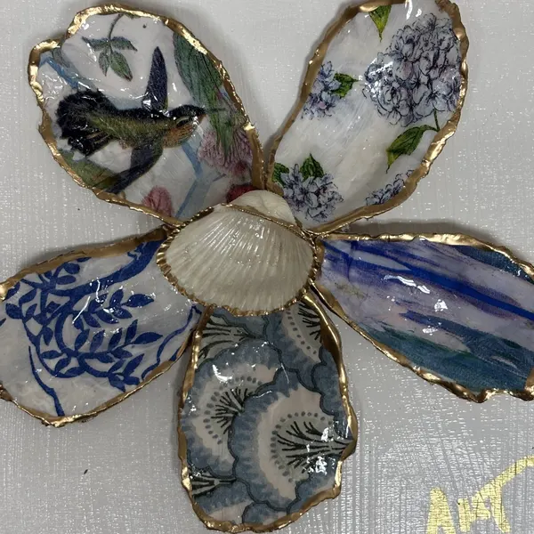 A six-petal shell flower wall art with hydrangea, hummingbird, and chinoiserie patterns around a pearl center.