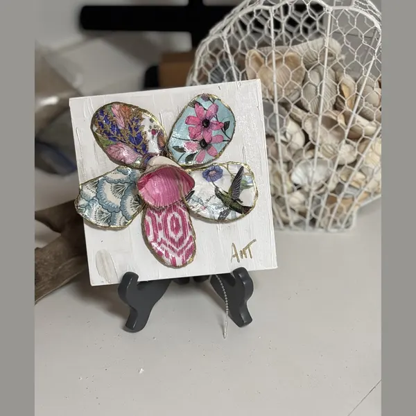 A six-petal shell flower wall art with pink floral, chevron, and swirl patterns around a pink center.