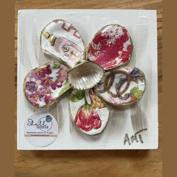 A six-petal shell flower wall art with pink floral and chinoiserie knot patterns around a pearl center.