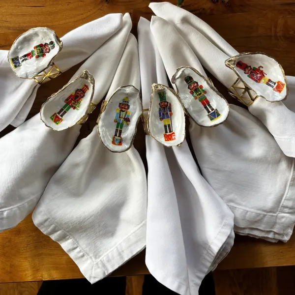 Gold-rimmed oyster shell napkin rings with colorful nutcracker soldiers and their drums, each one a little different.