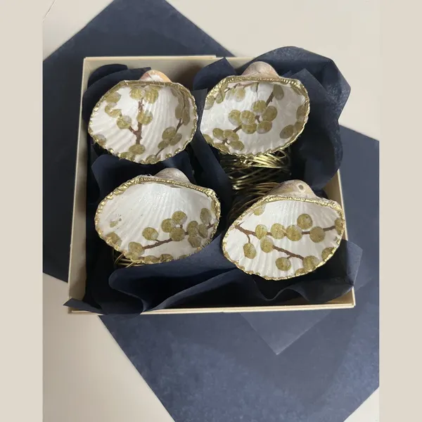 Gold-rimmed shell napkin rings featuring a gold berry branch.