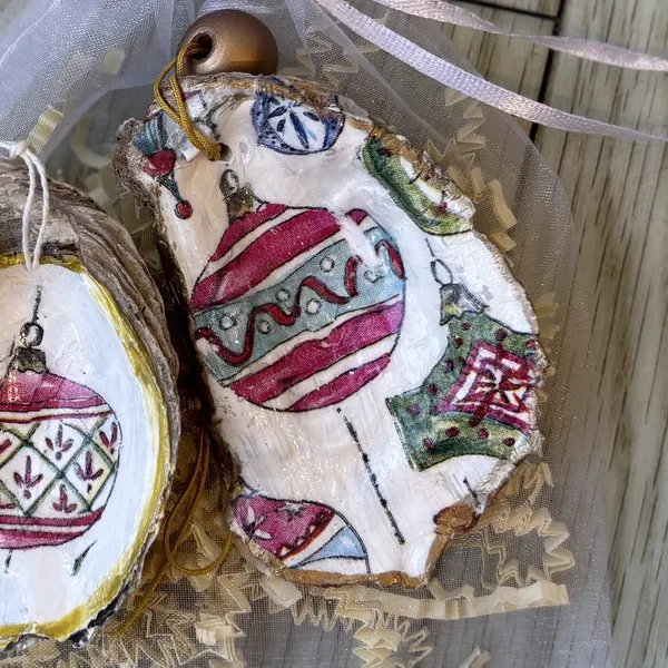 An oyster shell ornament covered in vintage Christmas baubles, finished with a wood bead. Comes in a gift bag.