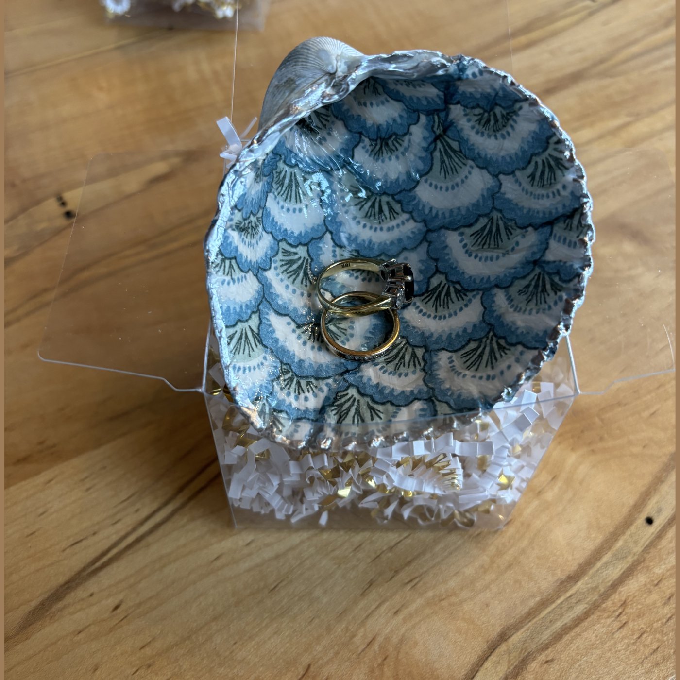A gold-rimmed shell ring dish with a blue and white fan pattern. Comes in a gift box.