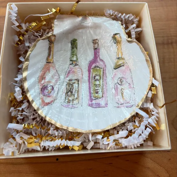 A shell dish featuring a row of celebratory bottles, gift-boxed.