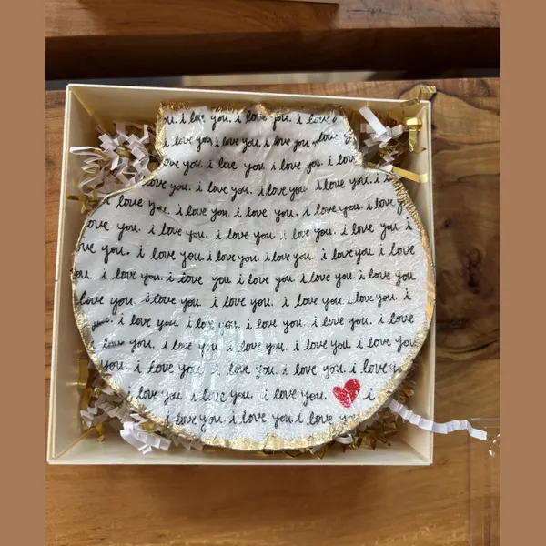 A shell dish hand-lettered in a repeating "I love you" script. Comes in a gift box.