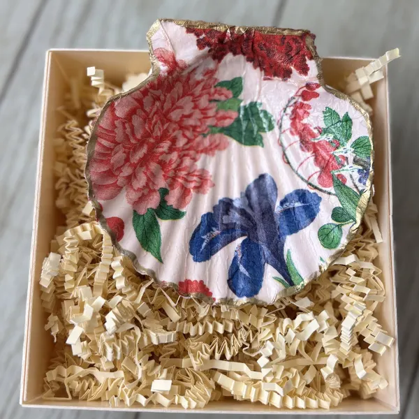 A gold-rimmed shell dish with a pink and red floral pattern, gift-boxed.