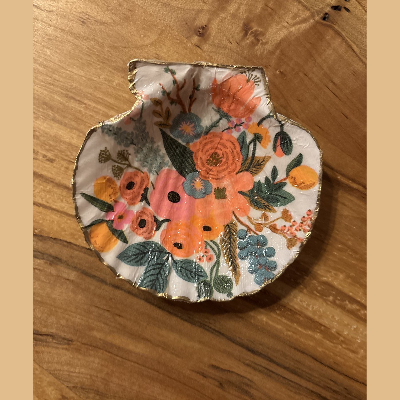 A shell dish with a bright floral pattern. Comes in a gift box.