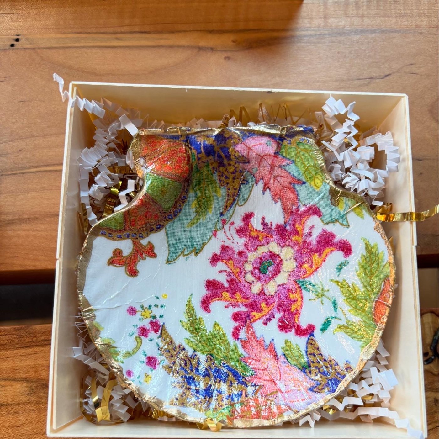 A gold-rimmed shell dish with a bold tobacco leaf and paisley pattern. Comes in a gift box.