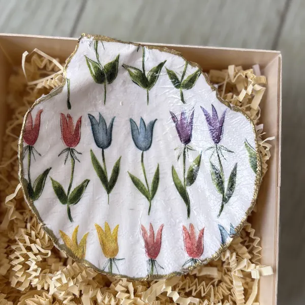 A gold-rimmed shell dish with rows of hand-drawn tulips. Comes in a gift box.