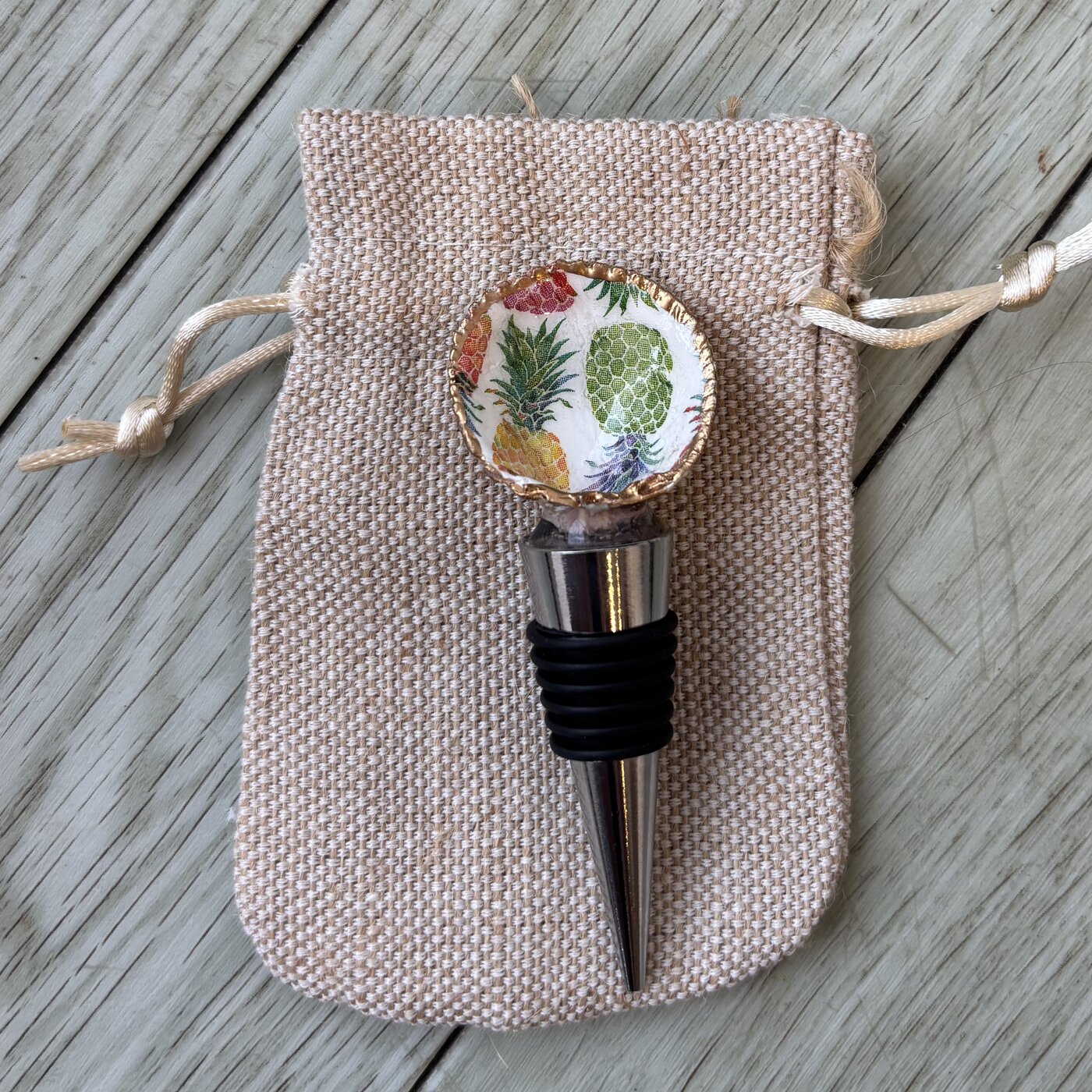A wine bottle stopper topped with a shell in a pineapple pattern.